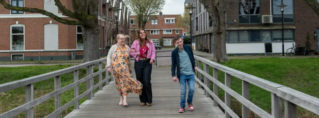 Drie mensen die over een brug lopen